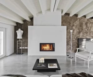 Insert de cheminée sous le toit, moderne et épurée blanc et mur taupe sur un sol en béton gris supportant une table noire.